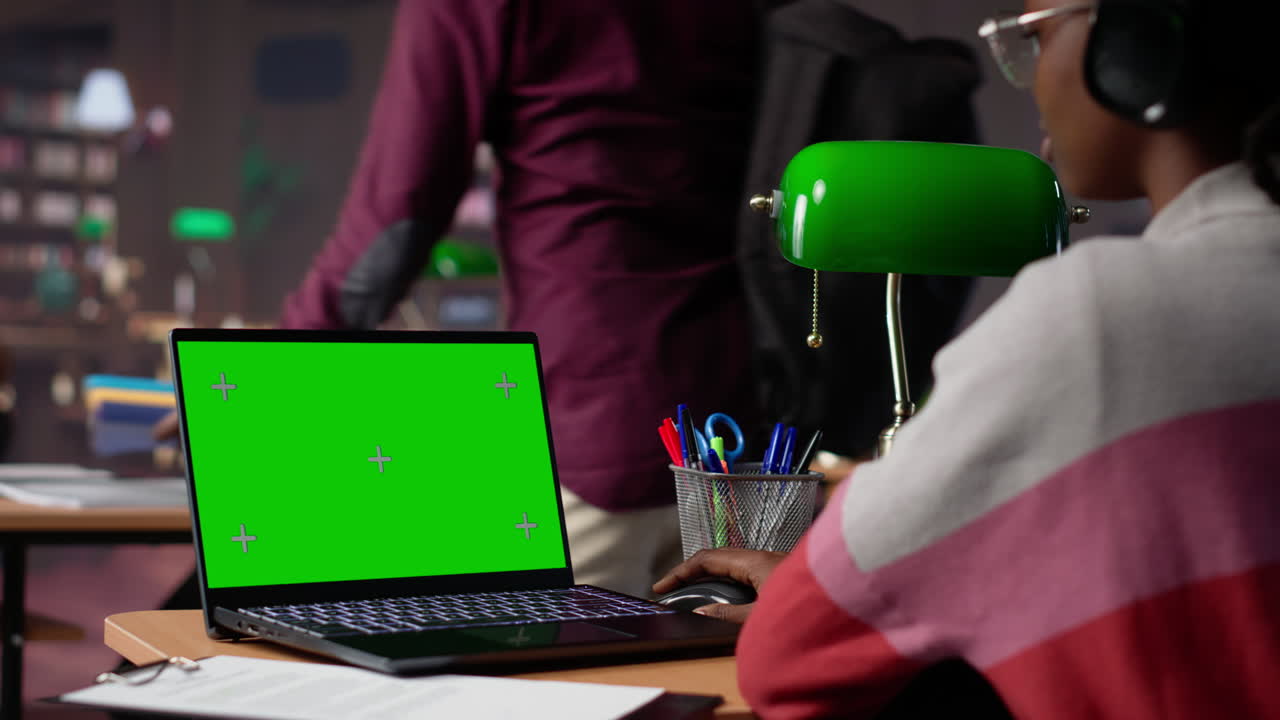 African american pupil uses green screen extracting citations from books