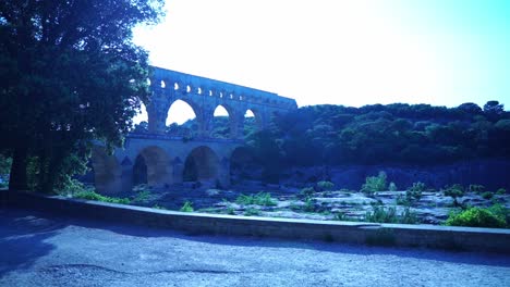 프랑스의 pont du gard에서 저녁에 일부 나무 뒤에서 강을 넘어 자연에서 찍은 사진