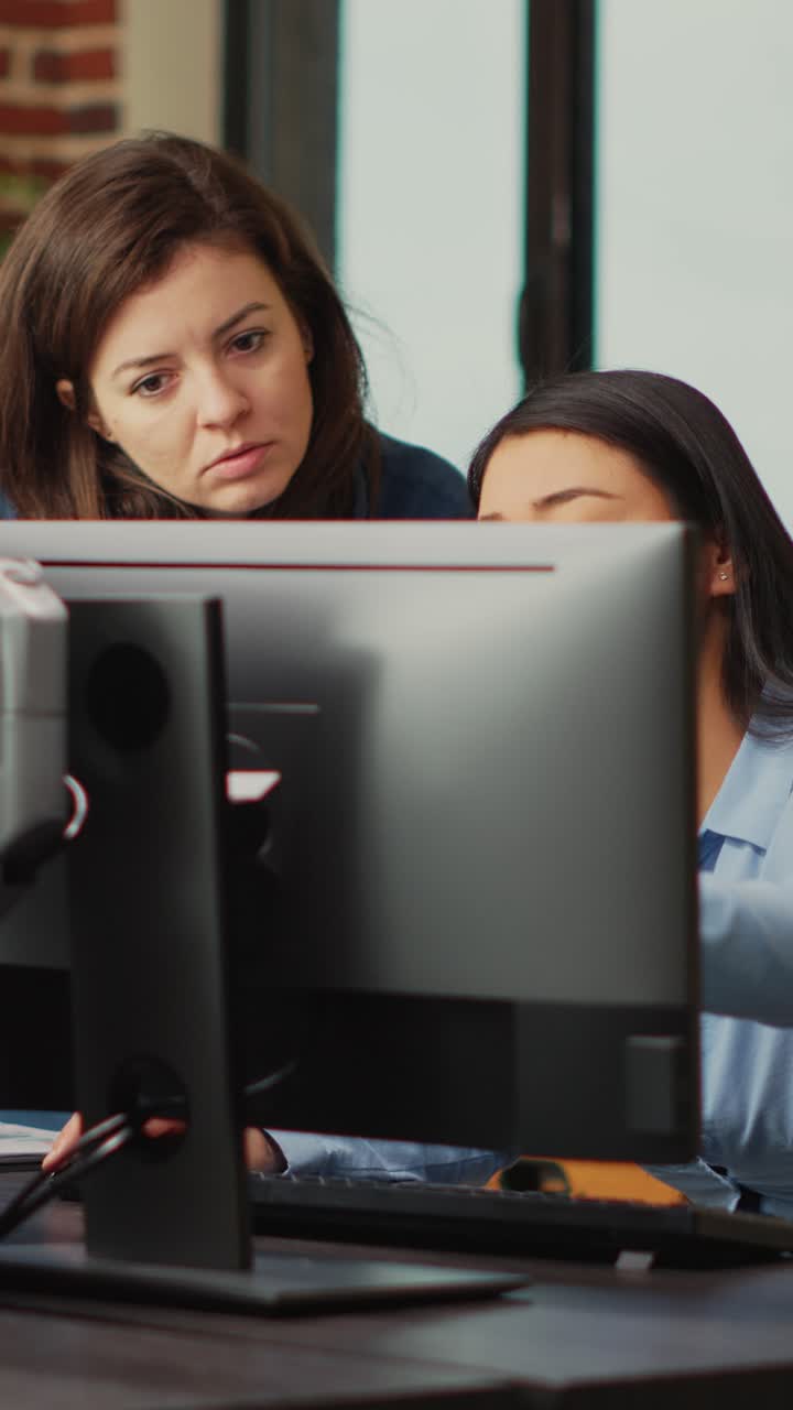 Vertical video: Diverse team of employees analyzing project component on multi screens