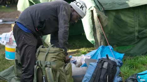 porter packs his backpack in the morning before starting his hike