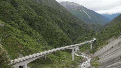 large truck driving over otira viaduct bridge with traffic stuck behind in arthurs pass new zealand