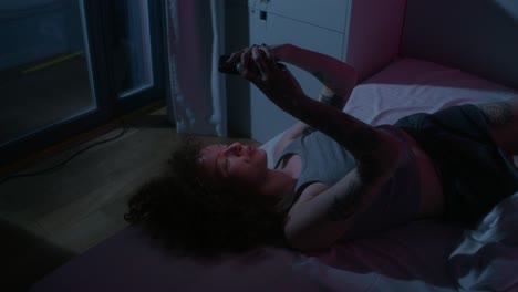 mujer usando teléfono inteligente en la cama por la noche