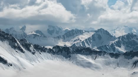 Vuelo-Aéreo-A-Través-De-Nubes-Montañosas-Sobre-Hermosos-Picos-Nevados-De-Montañas-Y-Glaciares.