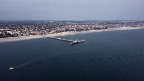 an amazing aerial drone shot, drone flying towards belmont veterans memorial pier in long beach, california