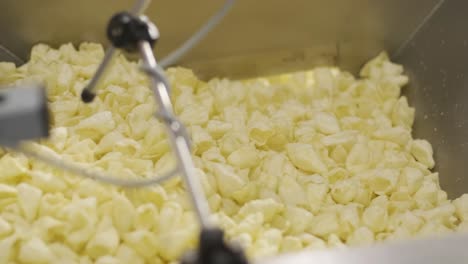 production factory line moves golden potato chips after frying, slow motion. production line of the pasta factory