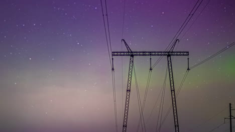 aurora borealis and night starry sky above high voltage power lines, time lapse