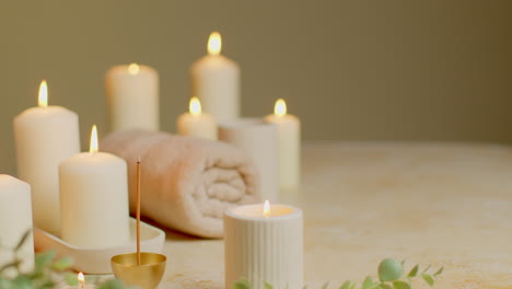 Bodegón-De-Velas-Encendidas-Con-Varillas-De-Incienso-De-Plantas-Verdes-Y-Toallas-Suaves-Como-Parte-De-Una-Relajante-Decoración-De-Día-De-Spa.