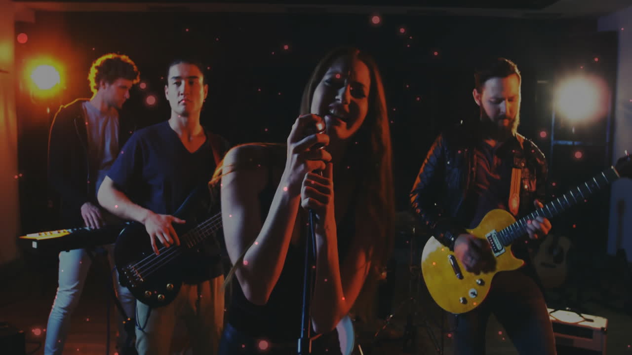 Music industry band performing on dimly lit stage, with spotlights glowing and particles floating