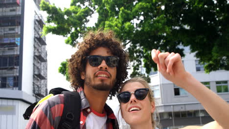 amigos de pie con la mujer señalando la mano hacia arriba