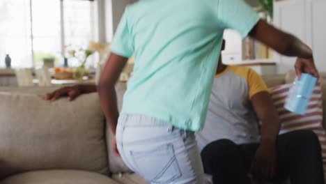 hija afroamericana dando a su padre un regalo en una caja de regalos