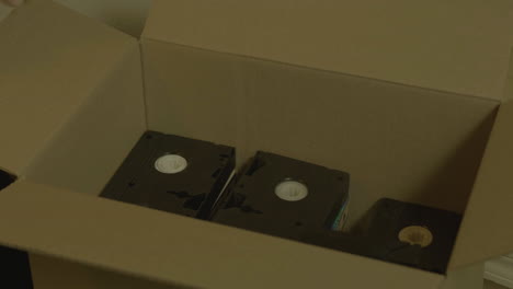 casetes de vhs en una caja de cartón