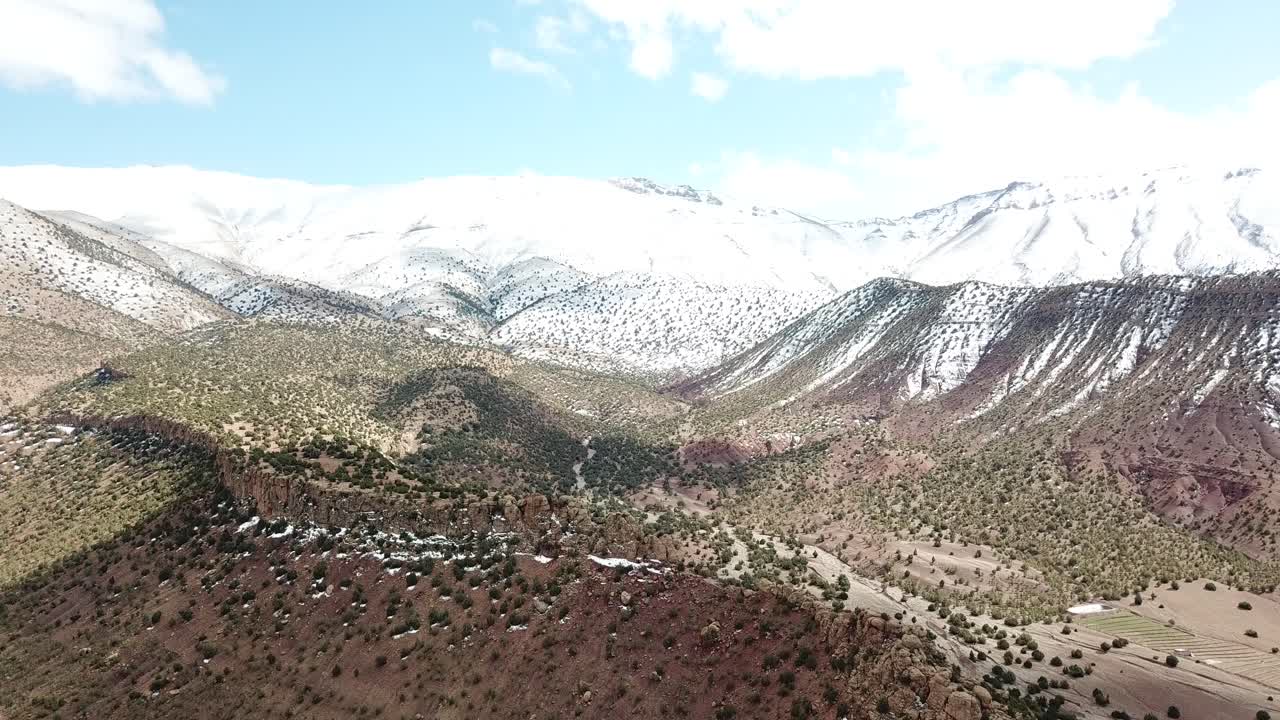 "Pristine snow crowns Morocco's Atlas peaks in winter splendor, where white powder cloaks jagged ridges and transforms the rugged landscape into a breathtaking alpine paradise."