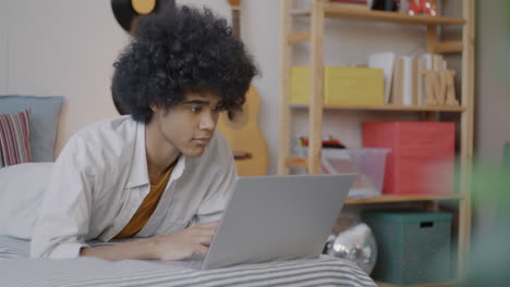teenager using laptop in bedroom