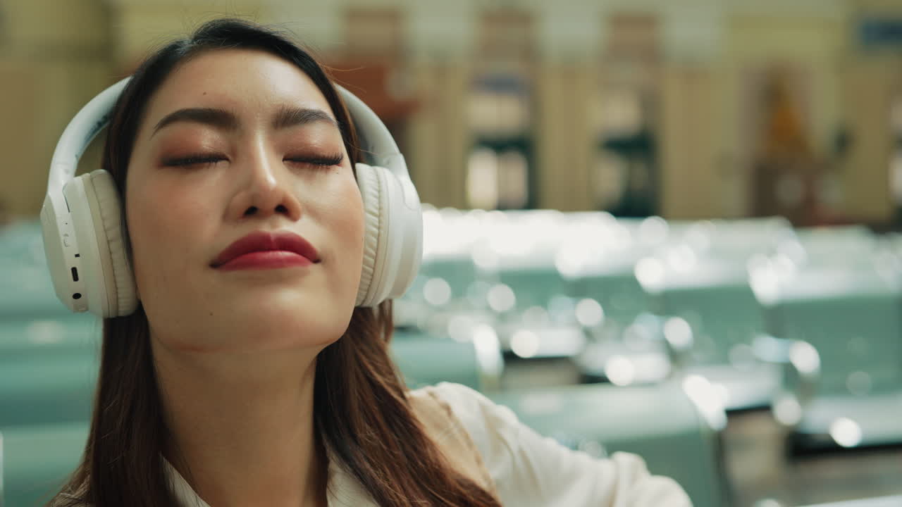 Woman Listening to Music in an Airport