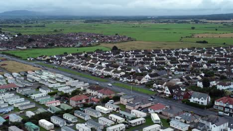 Static-caravan-trailer-beachfront-staycation-holiday-home-campground-resort-aerial-view-right-pan-across-farmland-countryside