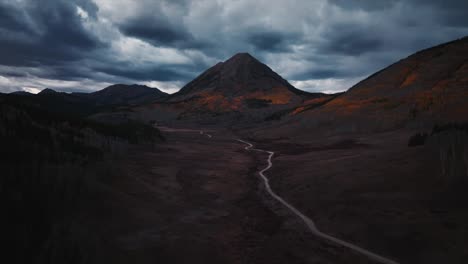Moody-dirt-road-leading-up-to-an-epic-mountain-peak-outside-of-Crested-Butte,-Co