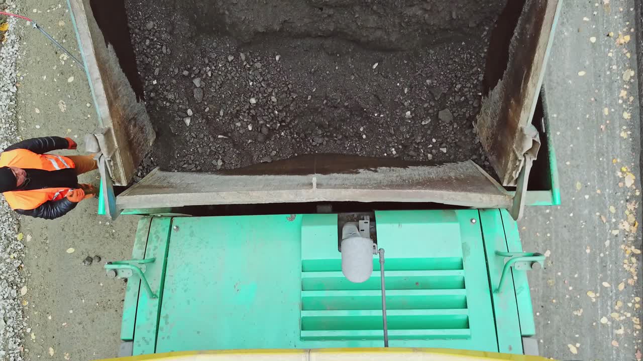 Asphalt road under construction. Construction machinery for the construction of a road in the forest