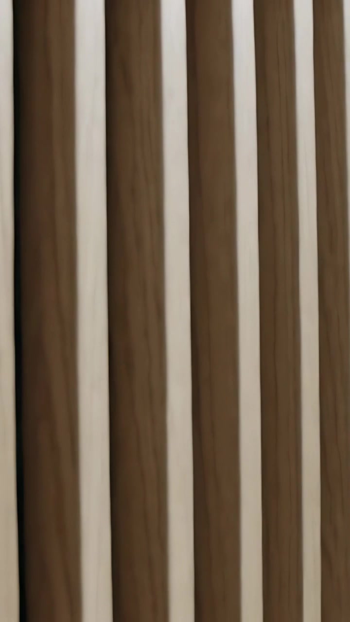 Video vertical: Cámara deslizándose capturando primer plano de panel de madera con listones en la pared, revelando la cálida veta.