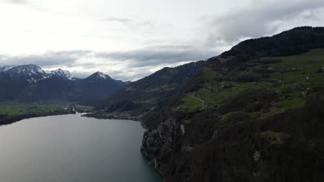 Parallax-aerial-shot-of-snow-covered-mountains-of-Walensee-during-cloudy-day-in-Switzerland