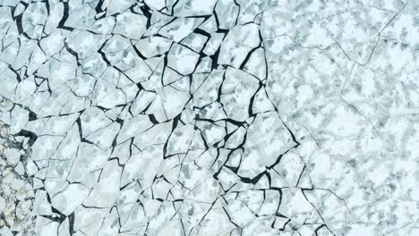 vuelo aéreo sobre la vista de los témpanos de hielo agrietados flotando en el mar