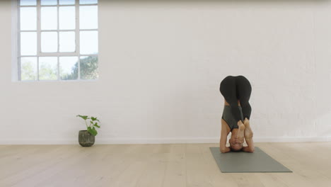 healthy yoga woman practicing headstand splits pose enjoying fitness lifestyle exercising in studio stretching beautiful body training on exercise mat