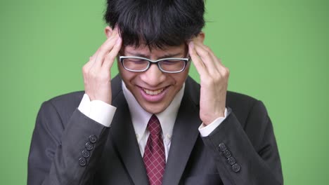 머리가 아프고 있는 젊은 스트레스를 받은 아시아 사업가