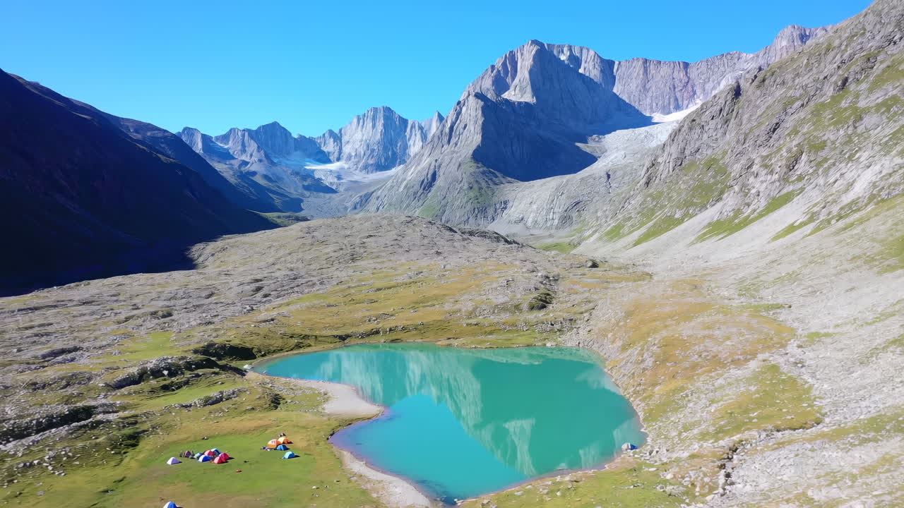Turkos alpin sjö med tält, glaciärmatade vatten som speglar taggiga toppar, färgglada backpackers slår läger