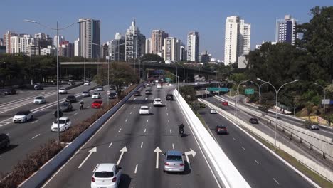 traffic on large freeway and skyscrapers cityscape, in a fair day in sao paulo, brazil