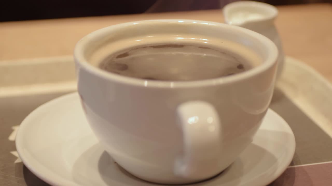 Cup of fresh coffee in a cup with serving of milk
