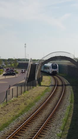 commuter train passing under a bridge