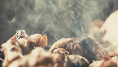 slow motion close-up shot of chicken wings and smoke from the charcoal grill