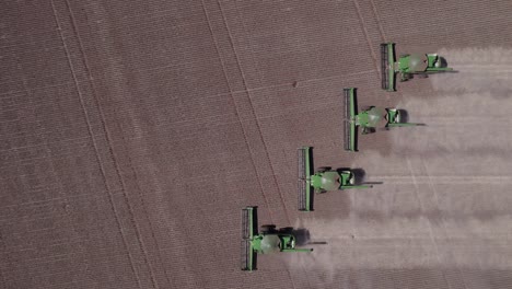 varios cosechadores descargando soja después de la cosecha