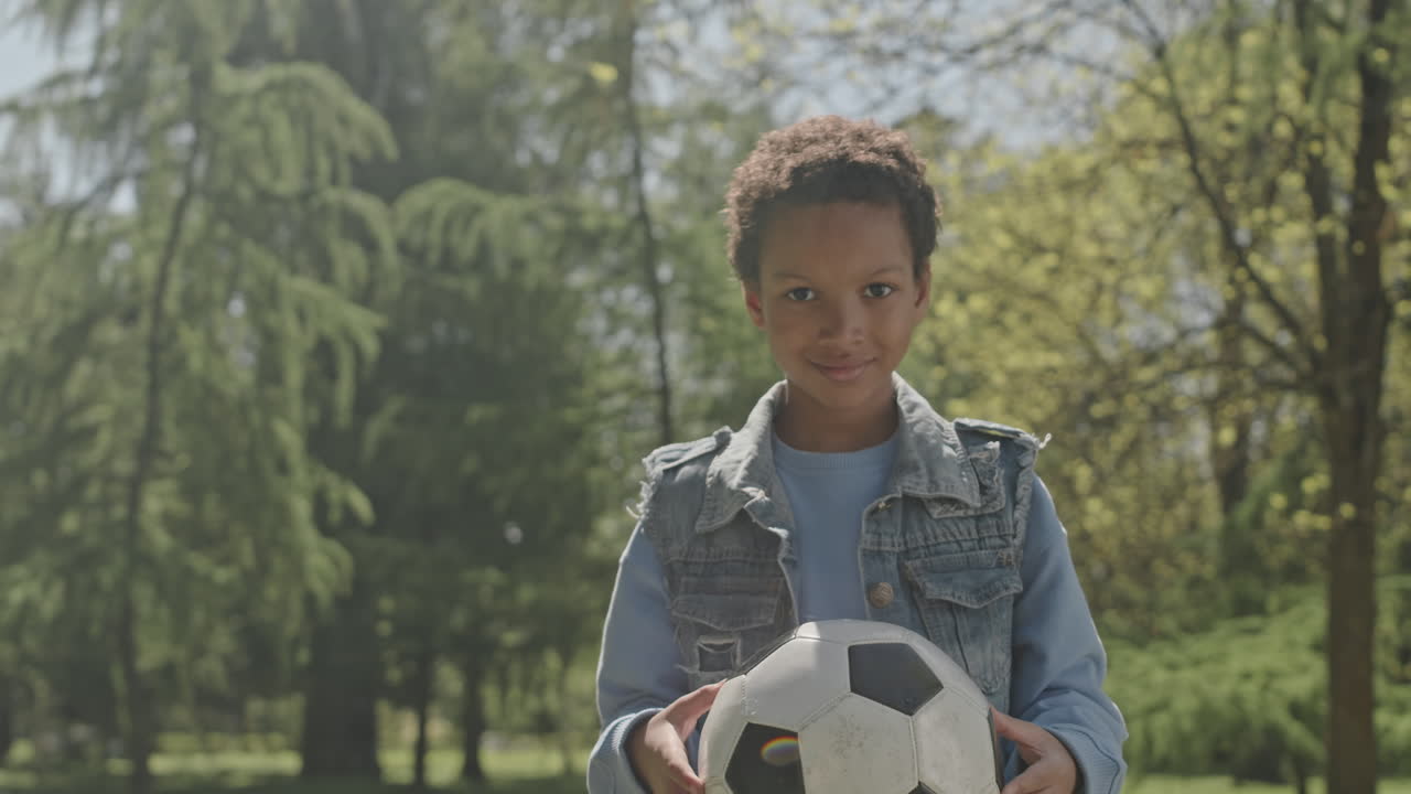 Portrait of Happy African American Boy with Soccer Ball in Park