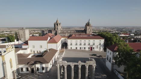 vista aérea hacia atrás sobre la plaza con un antiguo templo romano en el medio