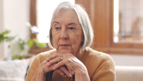 thinking, sad and senior woman on sofa in home