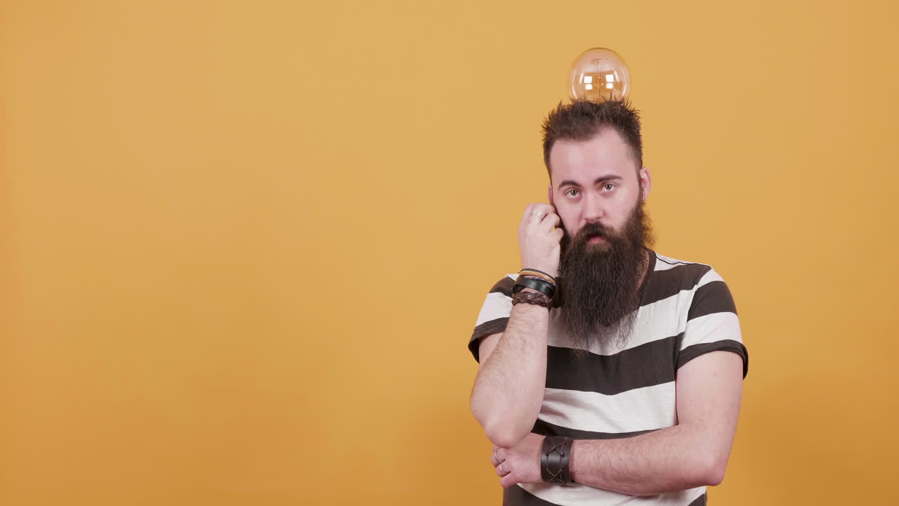 Man with beard and lightbulb thinking
