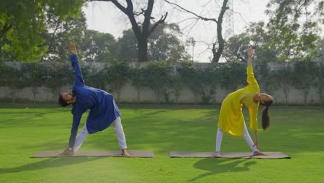 una pareja india haciendo ejercicios de estiramiento en un parque