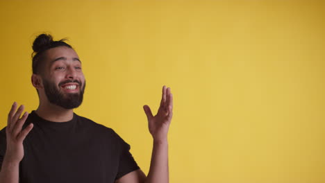 studio portrait of young man celebrating good news standing against yellow background 2