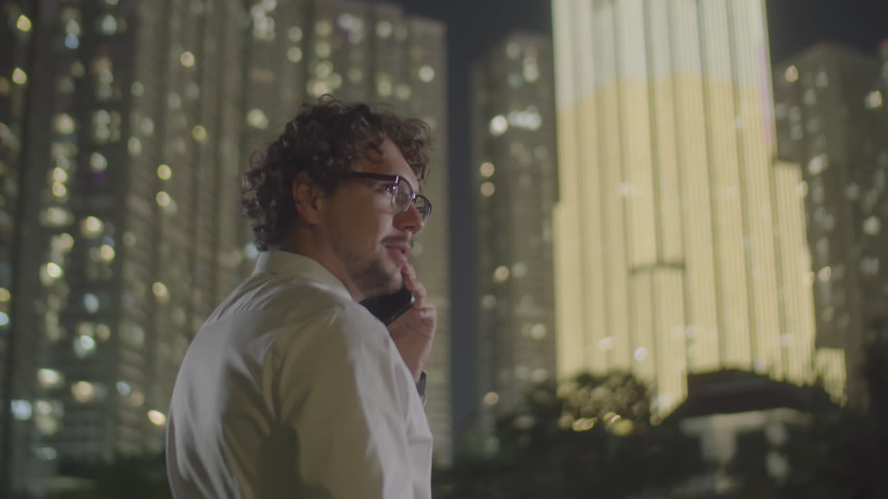 Businessman Talking on Phone in City at Night