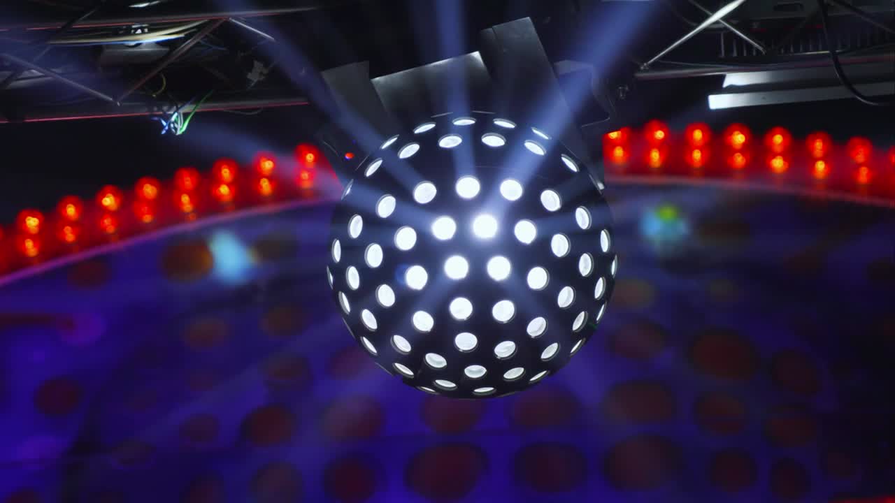 a atração no parque da cidade. bola giratória espelhada brilhante. decoração de luz intermitente multicolor da atração. raios de luz. iluminação led iluminada.