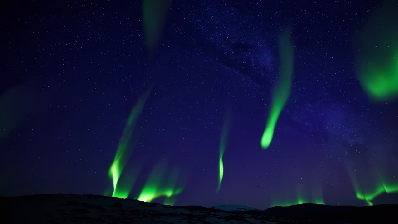 Vibrant Green Aurora Borealis Illuminating the Starry Night Sky