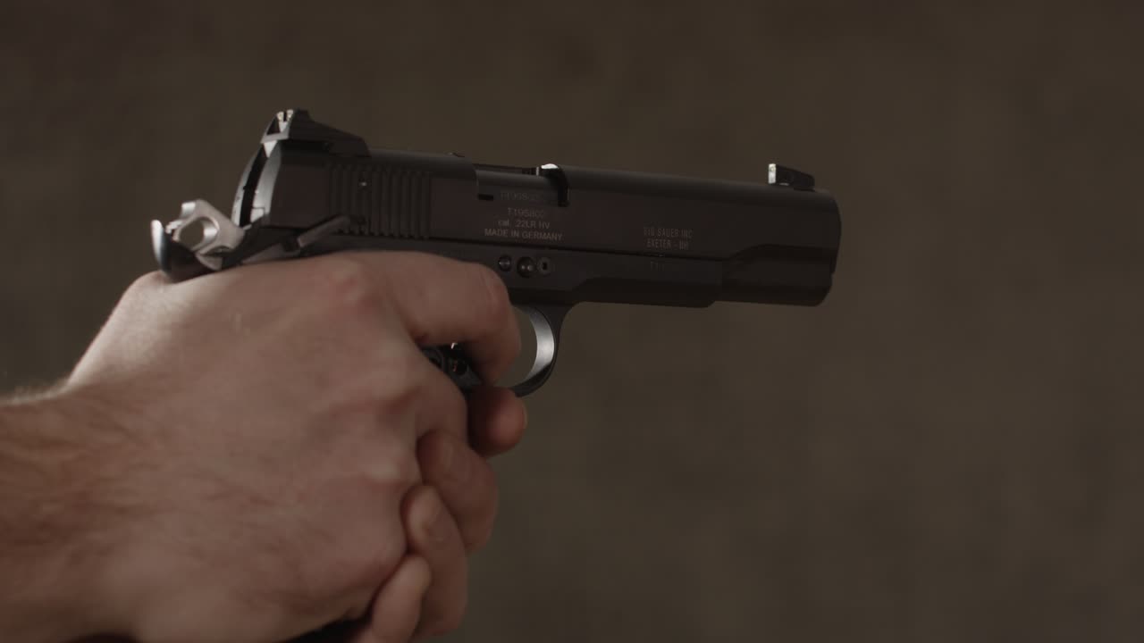Close up of small caliber pistol being held by Caucasian man
