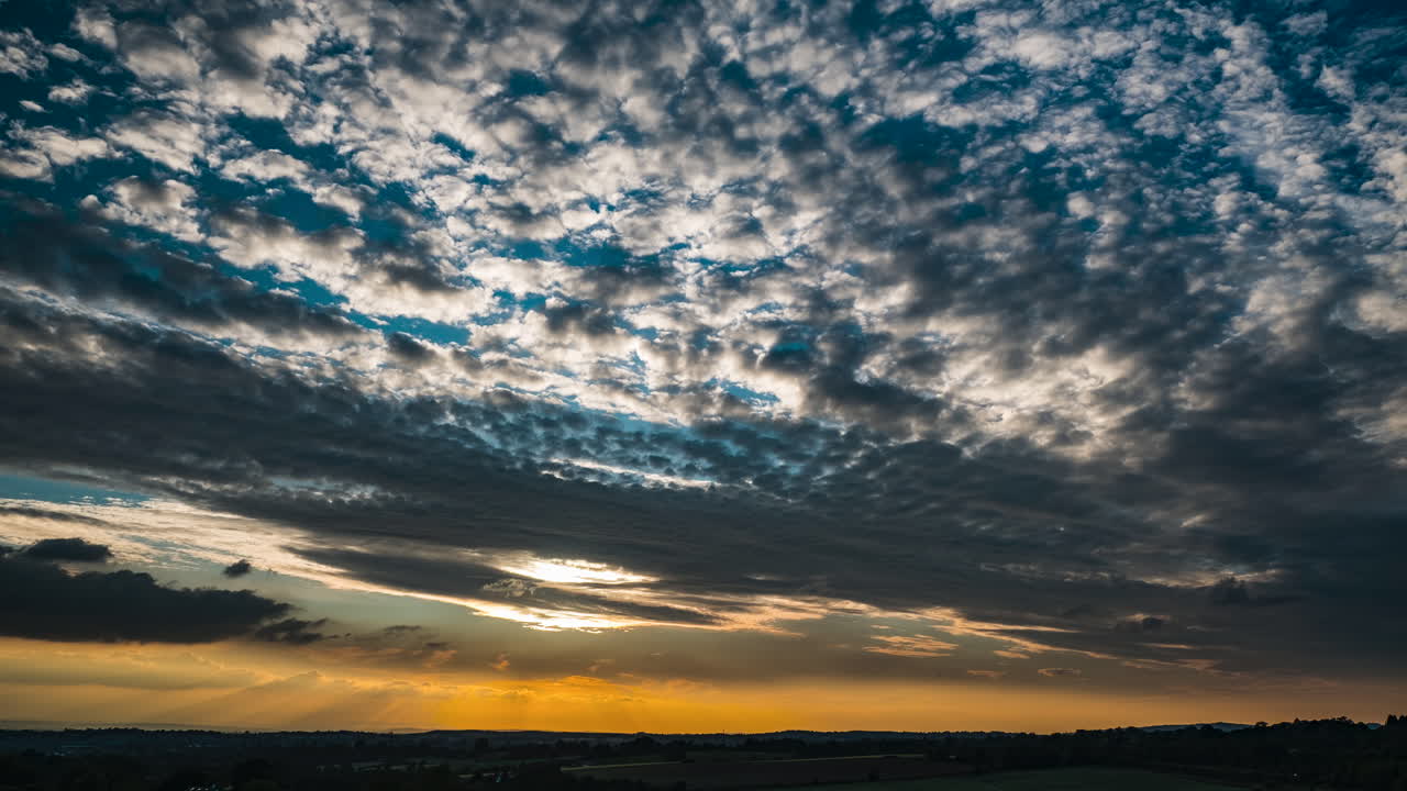 las nubes pasan en un lapso de tiempo de una gloriosa puesta de sol en una noche de junio sobre worcestershire, inglaterra, reino unido