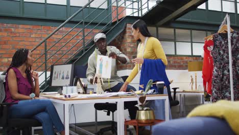 happy diverse fashion designers wearing the tape measures discussing work at office