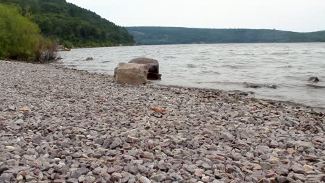 a rocky beach of a lake during a cloudy afternoon