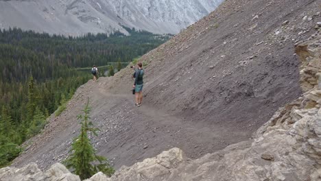 hiker on trail in mountain taking photographs kananaskis alberta canada