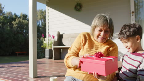 Feliz-Abuela-Birracial-Y-Nieto-Dando-Regalos-En-La-Terraza,-Cámara-Lenta,-Espacio-Para-Copiar