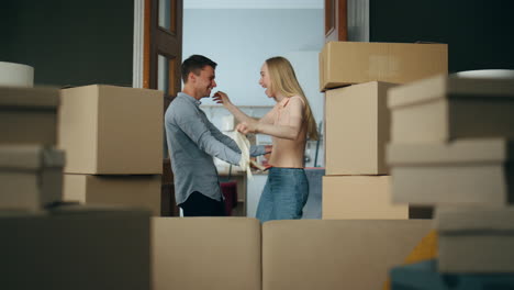 newlyweds hugging moving new apartment full of packed boxes. family relocation.