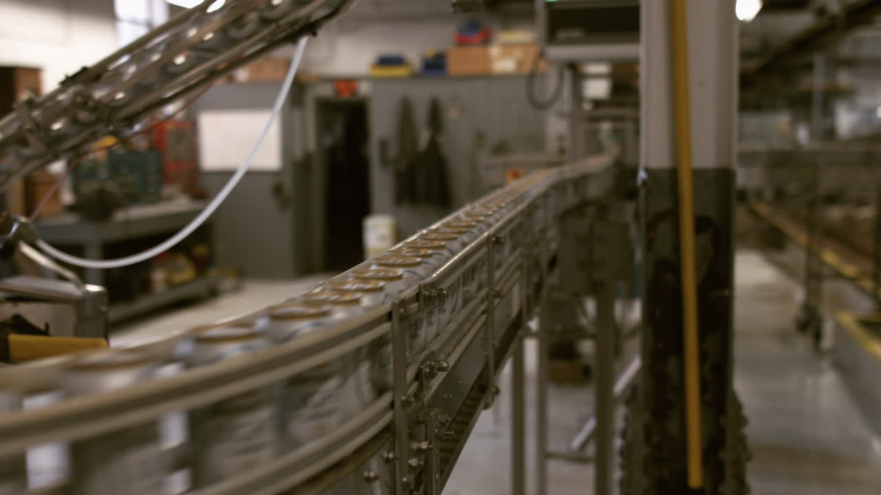 Cans traveling on conveyor line in manufacturing and bottling plant, dolly slider shot