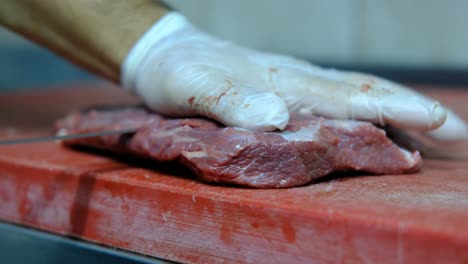 el chef corta carne cruda.